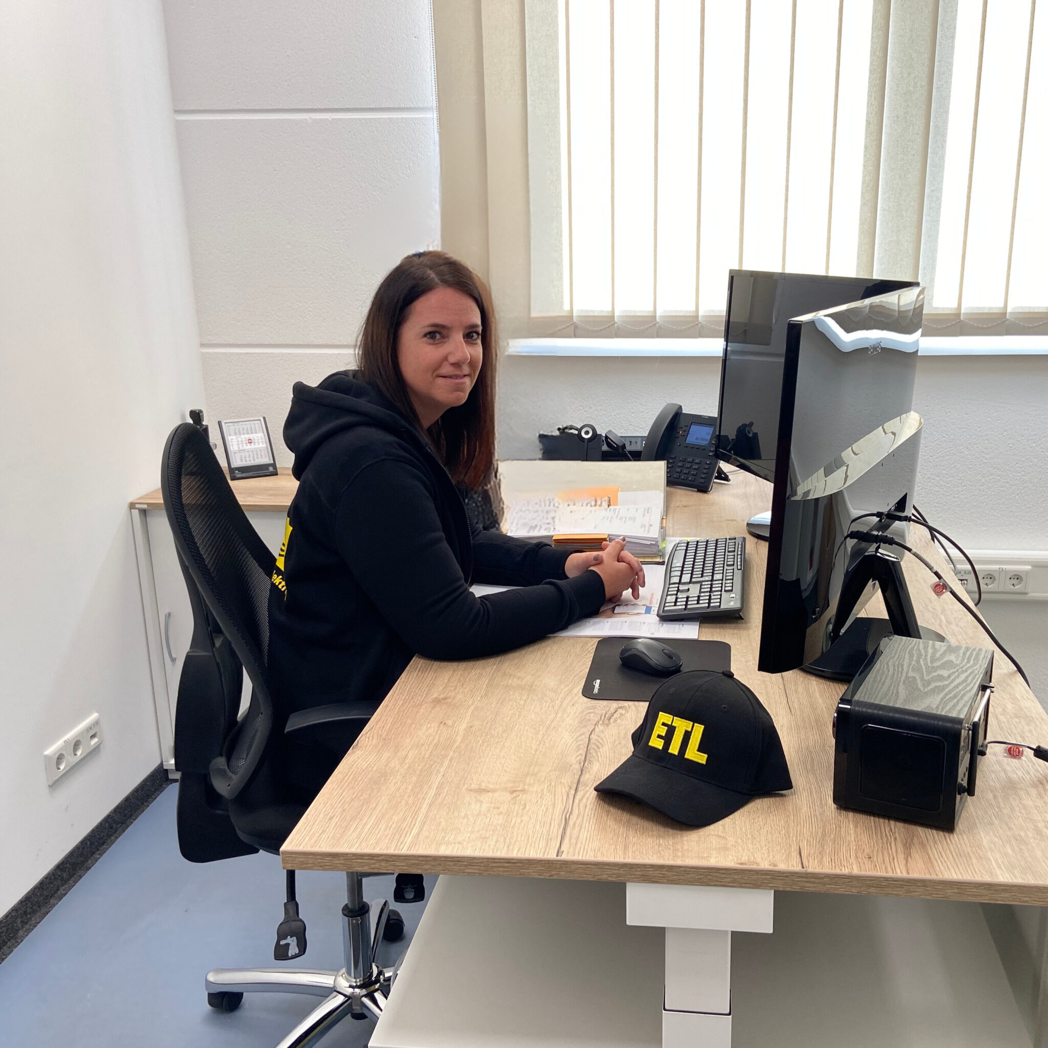 Mitarbeiterin sitzt am Tisch.